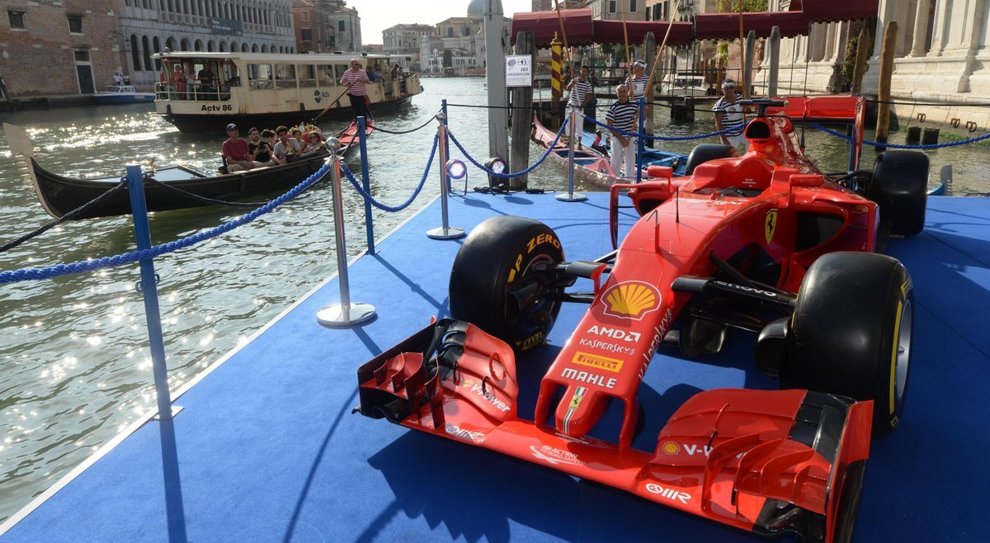 Una Ferrari F1 sul Canal Grande con l'alzaremi dei gondolini con gli equipaggi della Regata Storica a Ca'Vendramin Calergi con una 'rossa' parcheggiata su una chiatta in Canal Grande circondata dai gondolini, le formula uno del remo.
